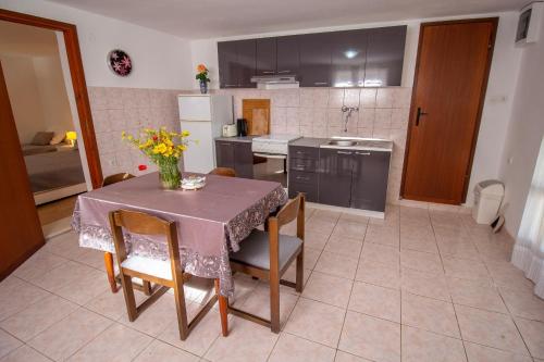 eine Küche mit einem Tisch und einer Blumenvase darauf in der Unterkunft Apartments Zvone - Apartments with terrace in Supetar
