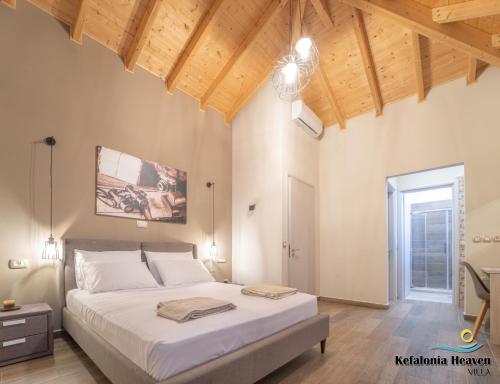 a bedroom with a large bed and wooden ceilings at Kefalonia Heaven Villa in Vlachata