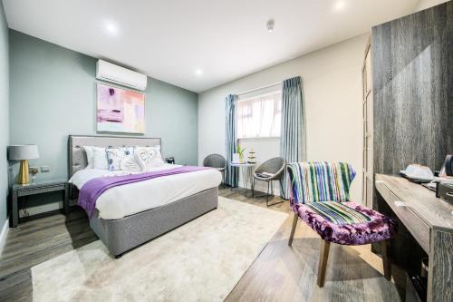 a bedroom with a bed and a desk and a chair at Villare Leicester City Centre hotel in Leicester