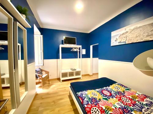 Habitación con paredes azules y cama. en Hostel Crespo en Lisboa