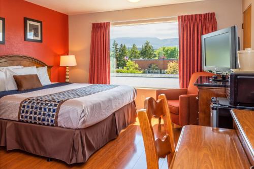 um quarto de hotel com uma cama e uma janela em Flagstone Motel em Port Angeles