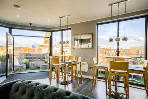 a living room with a couch and a table and chairs at Villare Leicester City Centre hotel in Leicester