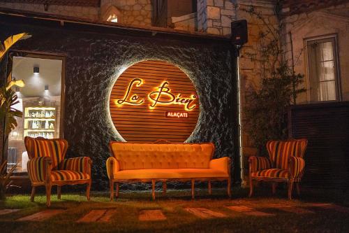 a bench sitting in front of a building with a sign at LA BİEN ALAÇATI in Cesme