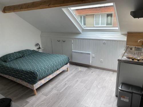 um quarto com uma cama e uma janela em Une escapade tranquille, proche de la plage ! em Dunkerque