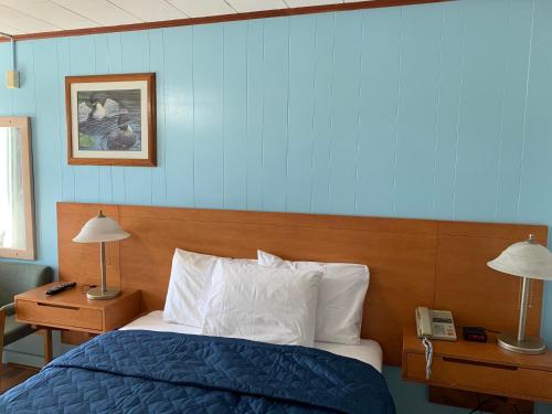 a bedroom with a bed and two lamps and a phone at Town & Country Motel in Parry Sound