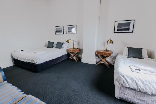 a room with two beds and two tables with lamps at Holmesville Hotel in Holmesville