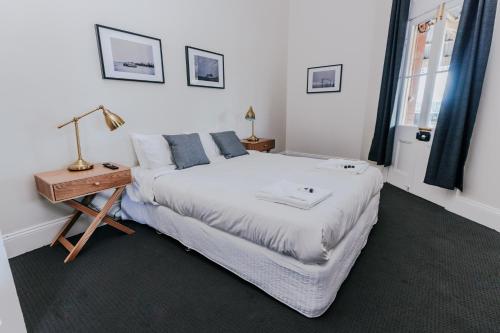 a bedroom with a bed and a table with a lamp at Holmesville Hotel in Holmesville