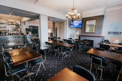 a dining room with tables and chairs and a bar at Holmesville Hotel in Holmesville
