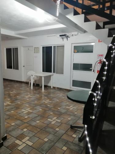 an empty room with a table and a staircase at Hostal Maple in Querétaro