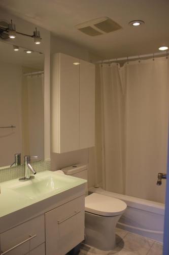 a bathroom with a sink and a toilet and a mirror at Your Vacation Home Downtown Vancouver in Vancouver