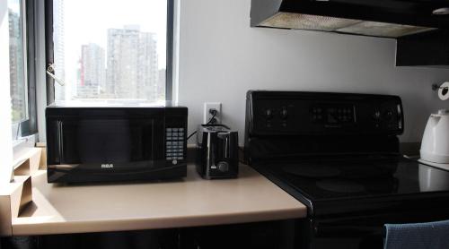 a kitchen with a microwave and a coffee maker on a counter at Your Vacation Home Downtown Vancouver in Vancouver