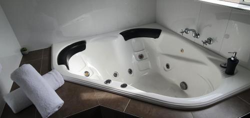 a white bath tub in a bathroom with a towel at Centrepoint Motel Deniliquin in Deniliquin