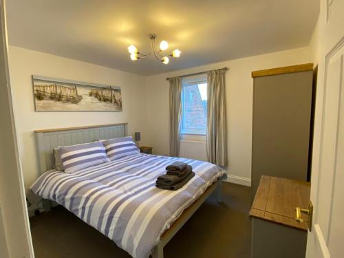 a bedroom with a bed with a pair of shoes on it at Penthouse Waterfront Apartment - St Neots in Saint Neots