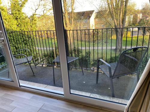 a screened in porch with two chairs and a table at Penthouse Waterfront Apartment - St Neots in Saint Neots