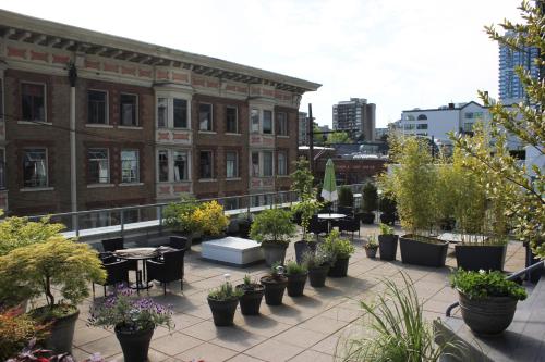 a patio with potted plants and tables and buildings at Your Vacation Home Downtown Vancouver in Vancouver