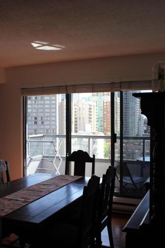 a dining room table with a view of a large window at Your Vacation Home Downtown Vancouver in Vancouver