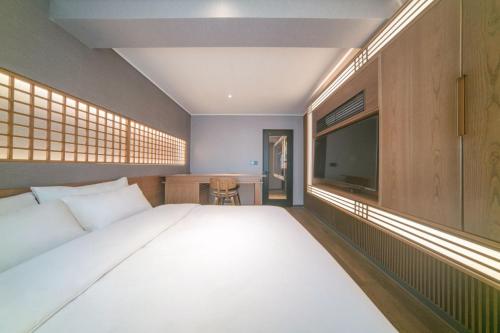 a bedroom with a large bed and a television at Yeon Hwa Moon Hotel in Incheon