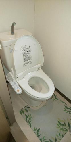 a bathroom with a toilet with a remote control at ホテルサンクリスター in Tokyo