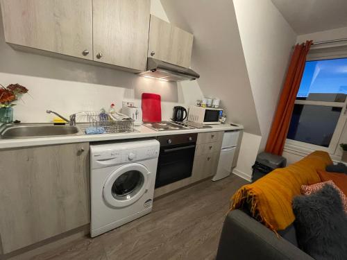 a kitchen with a washing machine and a sink at Carvetii - Edward House D - 2 Dbl bed 2nd floor flat in Dunfermline