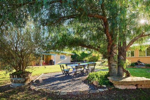 una mesa de picnic bajo un árbol en un patio en A Stanthorpe Getaway, en Ballandean