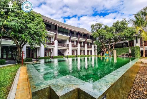 a swimming pool in front of a building at Smile Lanna Hotel in Chiang Mai