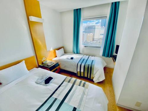 um quarto de hotel com duas camas e uma janela em Hotel Flex em Hiroshima