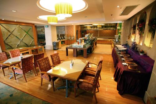 uma sala de jantar com mesas e cadeiras num restaurante em Jinyuan Jinling Plaza Xuzhou em Xuzhou