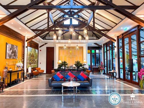 a lobby with couches and tables in a building at Smile Lanna Hotel in Chiang Mai