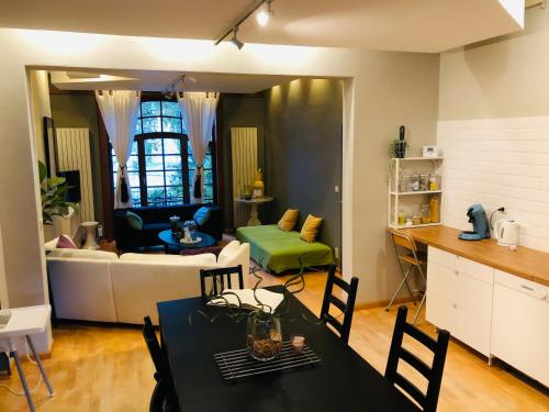 Apartment Easyway to sleep في بروكسل: مطبخ وغرفة معيشة مع طاولة وكراسي