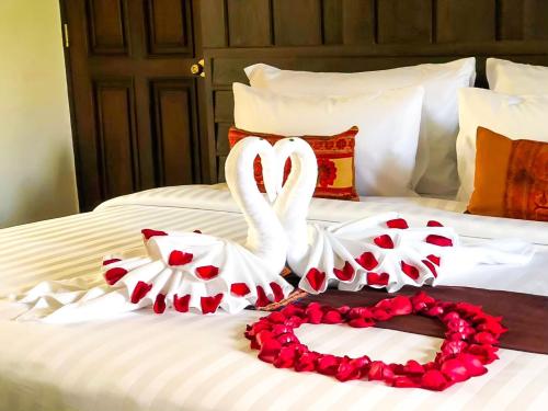 two swans are forming a heart on a bed at Smile Lanna Hotel in Chiang Mai