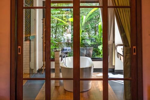 a bathroom with a tub through a glass door at Smile Lanna Hotel in Chiang Mai