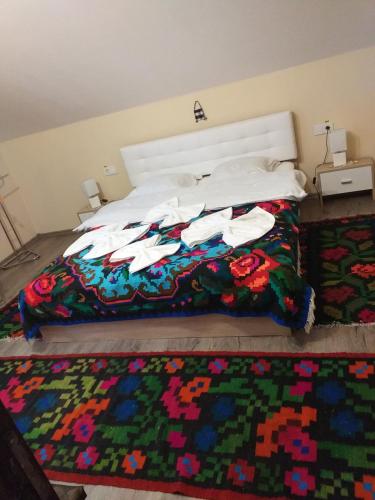 - une chambre avec un lit et une couverture colorée dans l'établissement Casa Alina Breb, à Breb