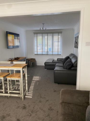 a living room with a couch and a table at Riverside Park Ground Floor Apt 1 BR Parking St Neots in Saint Neots