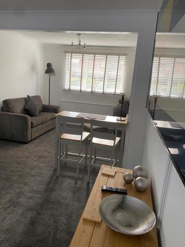 a living room with a table and a couch at Riverside Park Ground Floor Apt 1 BR Parking St Neots in Saint Neots