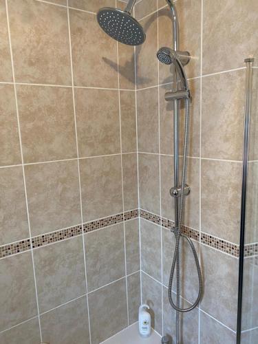 a shower with a shower head in a bathroom at Riverside Park Ground Floor Apt 1 BR Parking St Neots in Saint Neots