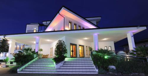 a white house with lights on the stairs at night at Hotel Palace Savuto in Malito