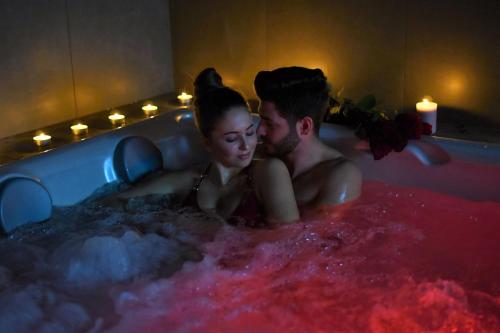 a man and a woman sitting in a bath tub at Wellness Baška in Baška