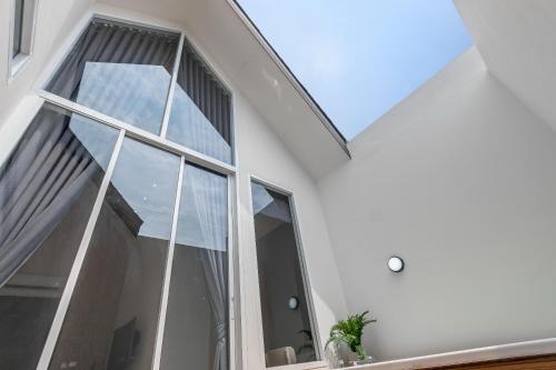 a large window in a white house with a roof at Nidhra นิทรา in Ban Lat Krachaeng