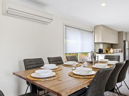 a dining room with a wooden table and chairs at Amersham in Callala Bay
