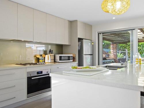 a kitchen with white cabinets and a white counter top at Amersham in Callala Bay