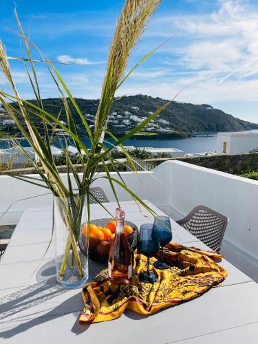 a table with a bottle of alcohol and a plate of food at Modern Cycladic Sea View House in Ornos