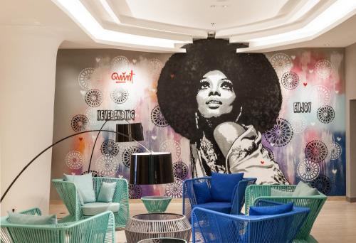 a room with chairs and a mural of a woman at Solia Legian Bali in Legian