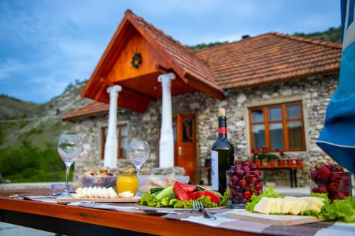 una mesa con comida y copas de vino y una casa en Casa Agricultorului Varzari, en Butuceni
