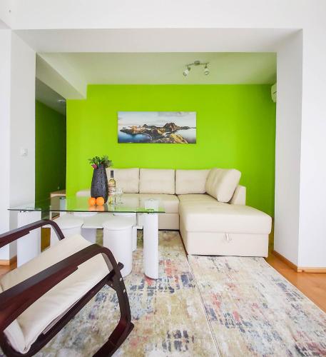 a living room with a couch and a green wall at Villa Makeli in Rogachevo