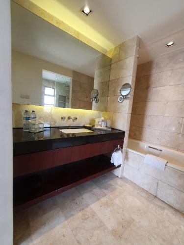 a large bathroom with a sink and a tub at Hotel Gran Mahakam in Jakarta