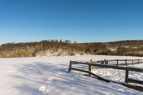 a snow covered field with a fence in the foreground at Ferienhof Homann Sauerland in Brilon