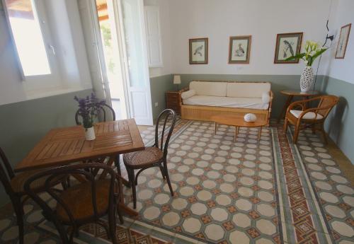 sala de estar con cama, mesa y sillas en Villa le Pigne, en Malfa