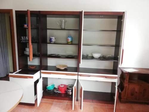 um armário com prateleiras de vidro numa cozinha em Casa Rosaguta em Vescina