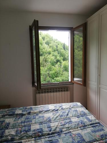a bedroom with a bed and a large window at Casa Rosaguta in Vescina