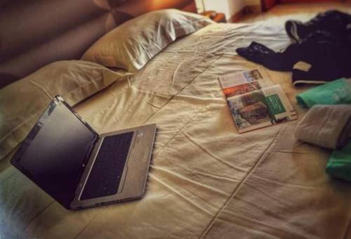 un ordenador portátil sentado en la parte superior de una cama en B&B Gianninella, en Agropoli